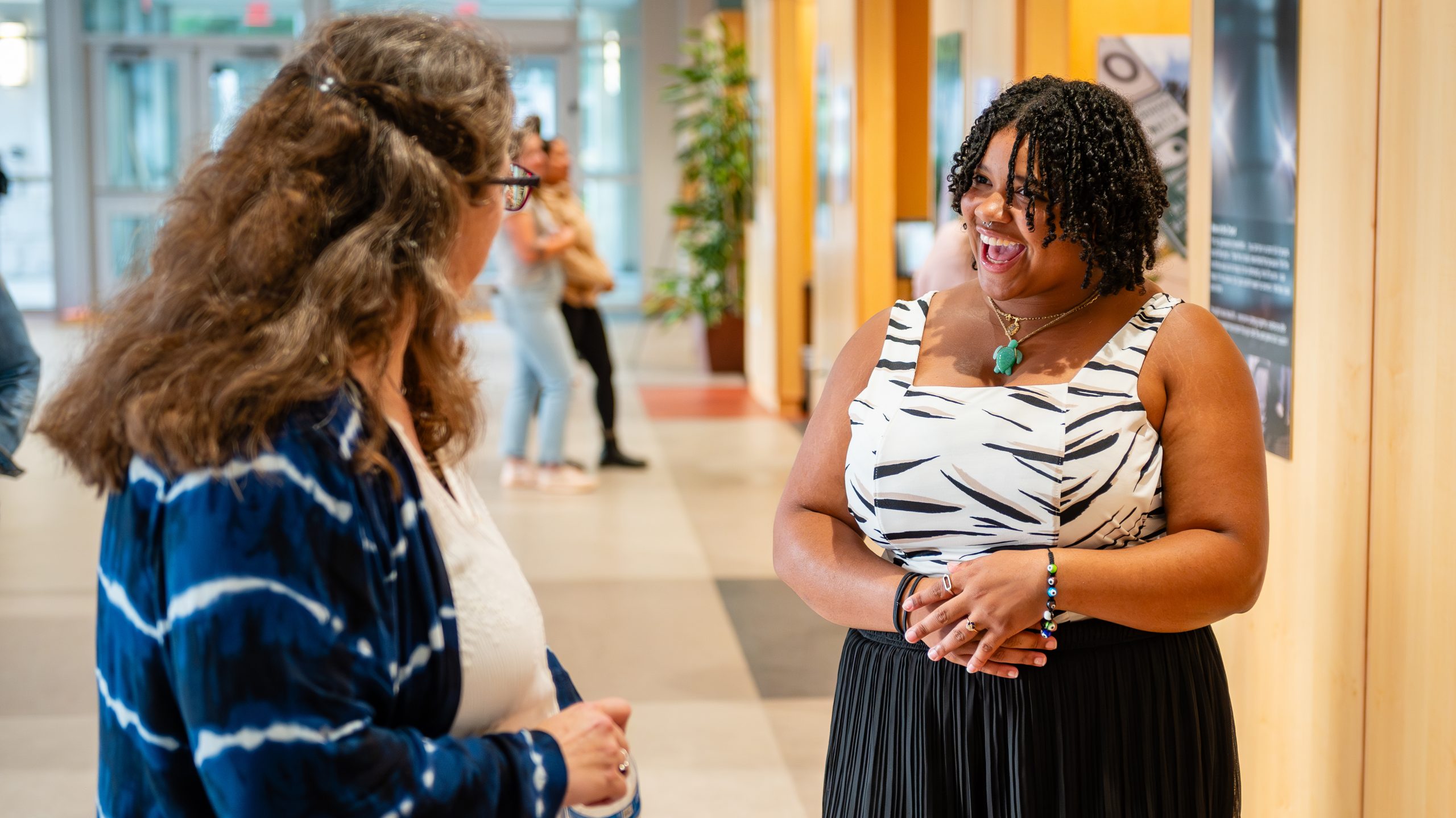 Willow Burgess-Johnson speaks with a teen at the NC Voices Amplified photovoice exhibit