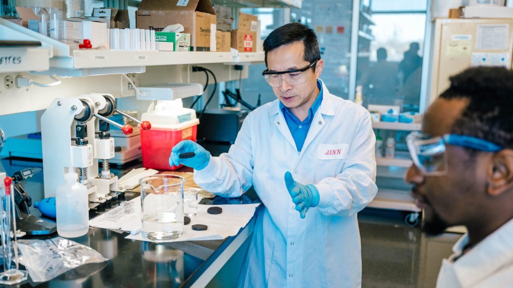 Dr. Jianjun Wei works in his lab with biochar as a research assistant observes
