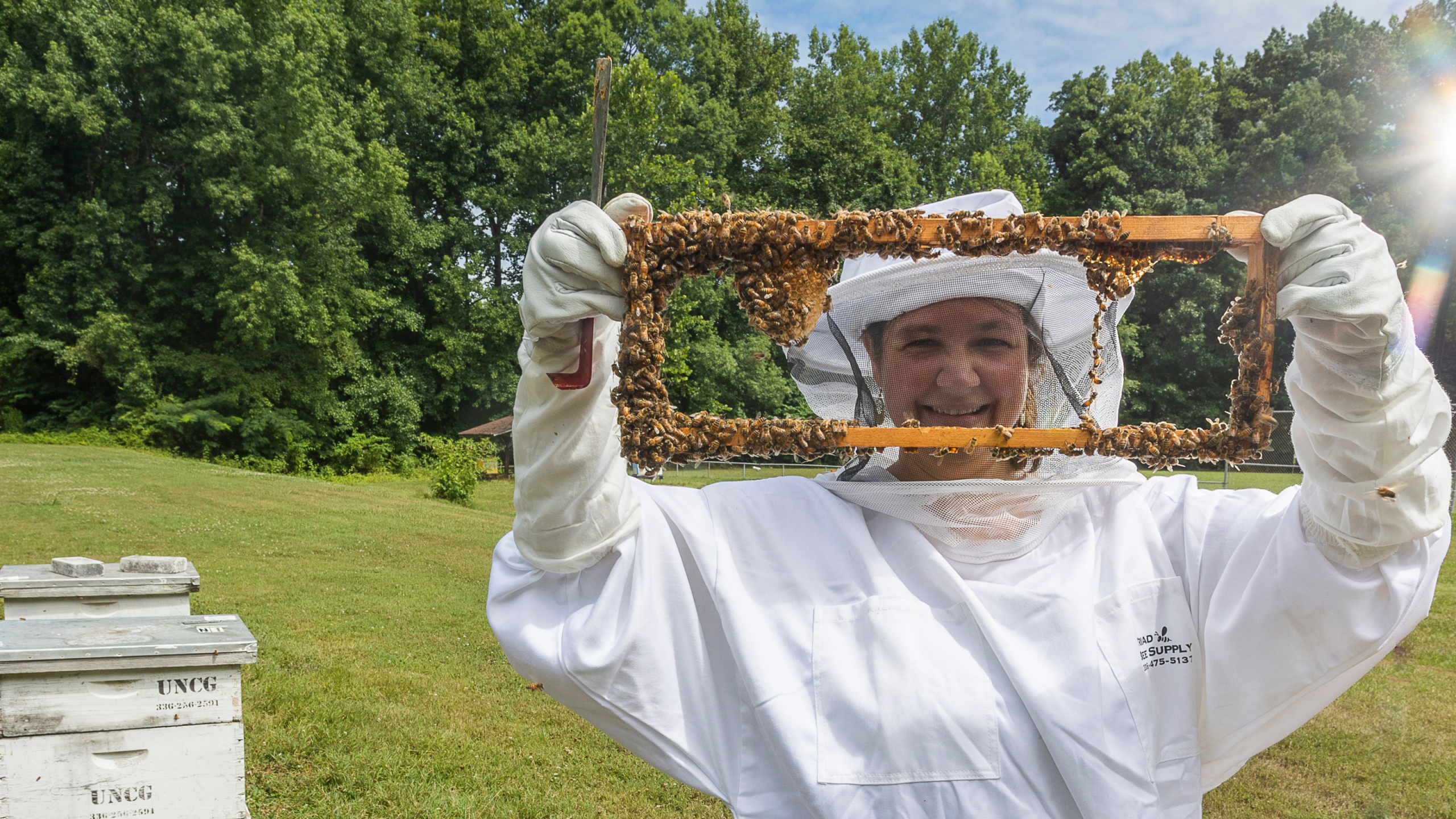 Dr. Kaira Wagoner holds up part of a honeybee hive